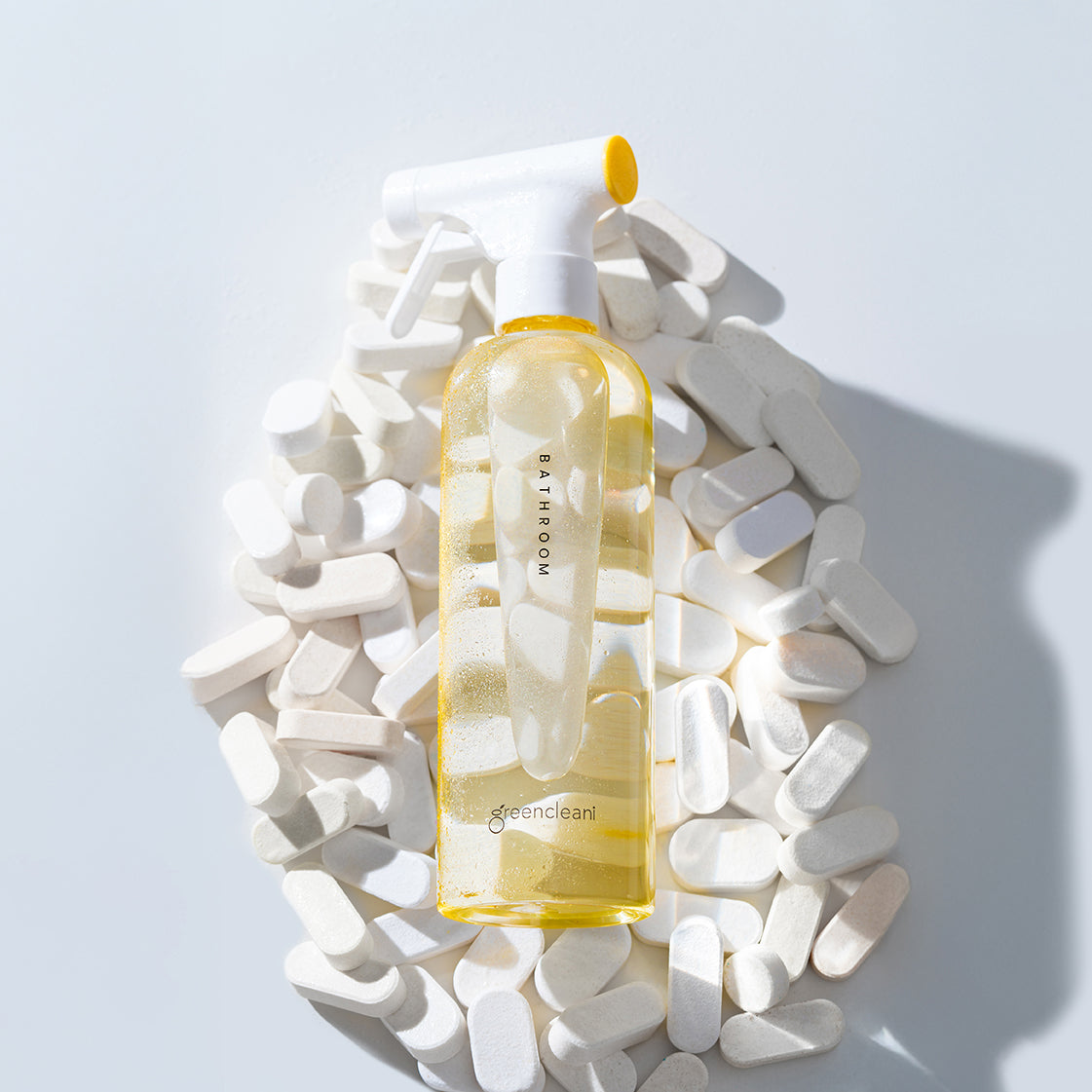 The yellow Greencleani Bathroom cleaner spray bottle, included in the Eco-Starter Kit, alongside its eco-friendly cleaning tablets. Part of our refillable, non-toxic cleaning system