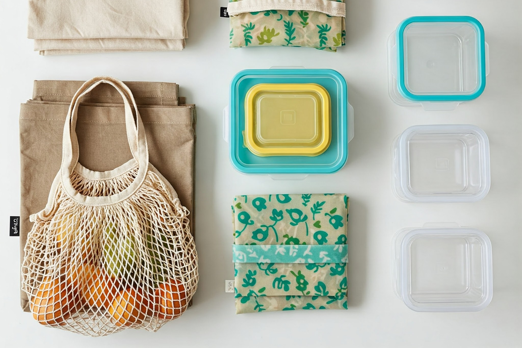 Flat lay of reusable kitchen items like a mesh produce bag, cloth bags, and food containers, illustrating simple swaps for a plastic-free kitchen. Eco-tips by Greencleani for Malaysian homes