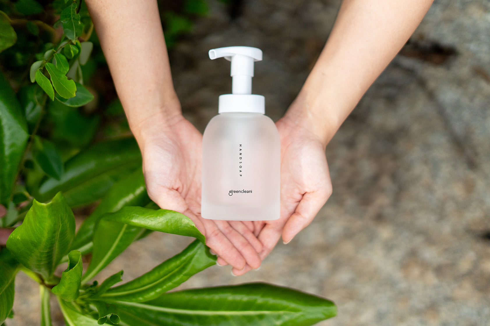 Greencleani frosted glass handsoap dispenser held gently, symbolizing our commitment to less plastic and mindful communication. Stay in touch for eco-friendly updates