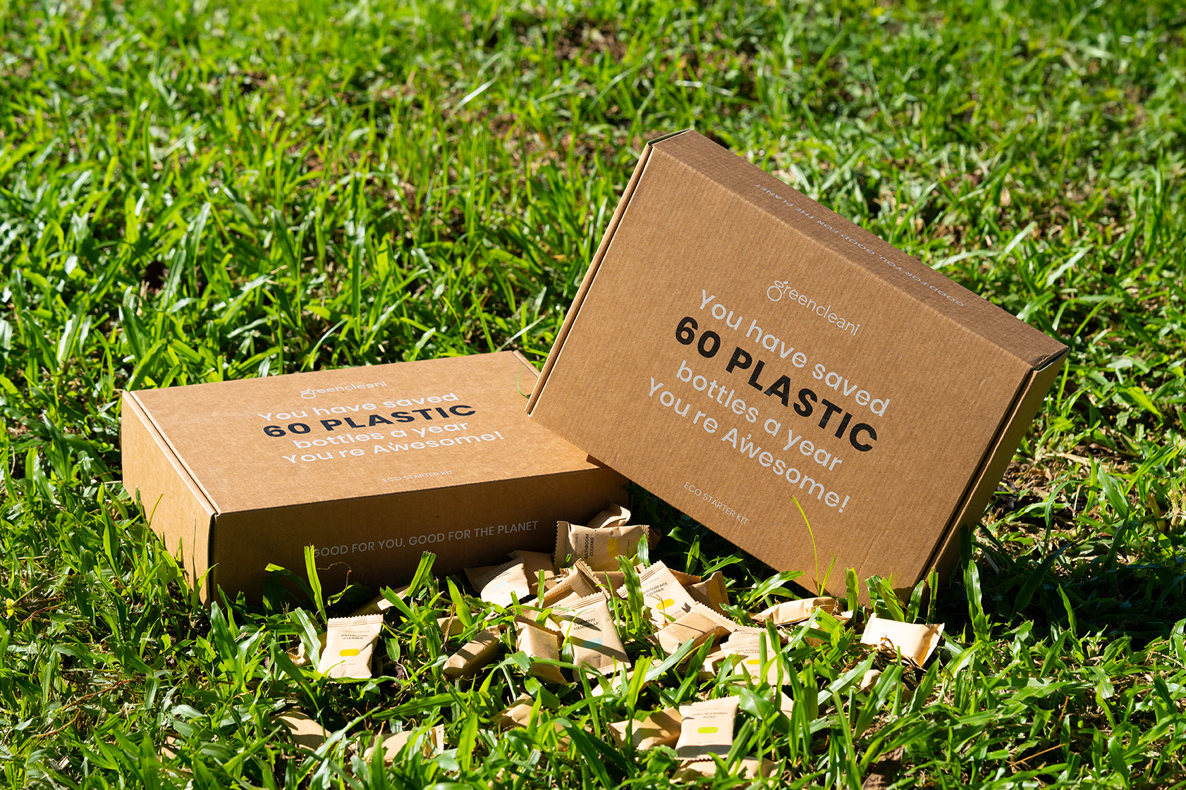 Greencleani starter kit boxes made from recycled materials, promoting less plastic waste with the message 'Save 60 plastic bottles a year'. Our packaging promise for a greener Malaysia